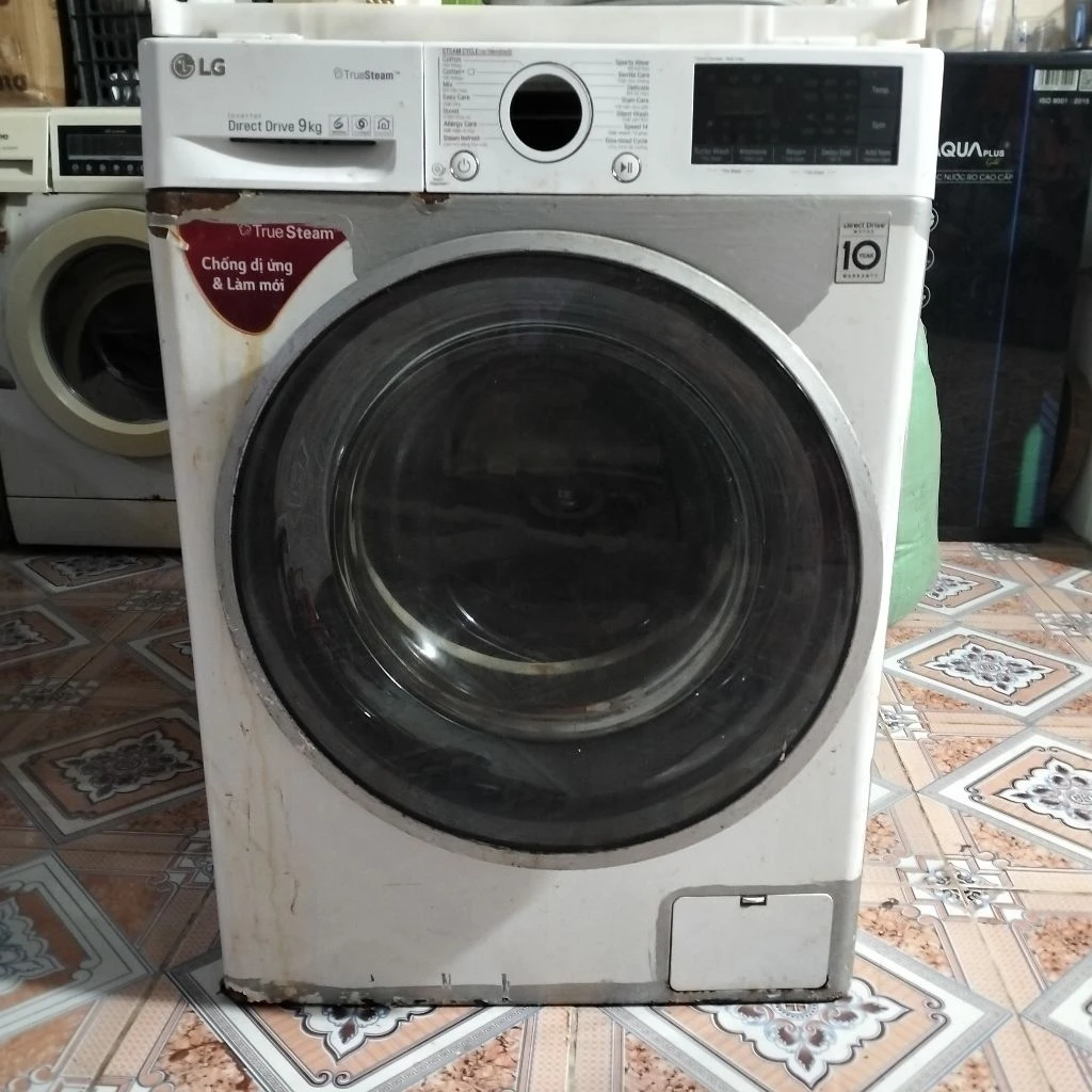 Máy giặt cửa trước LG FC1409S2W màu trắng, có màn hình điều khiển kỹ thuật số và cửa kính trong suốt.