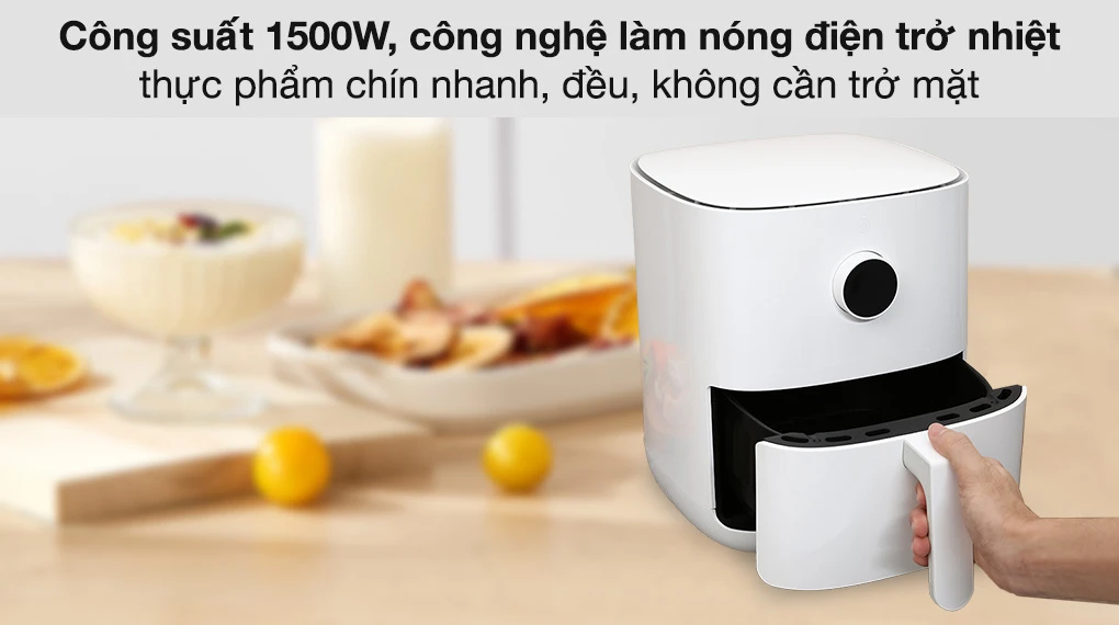 Nồi chiên không dầu Xiaomi Mi Smart Air Fryer 3.5L màu trắng, đang được mở cửa lấy đồ, đặt trên bàn bếp với các món ăn xung quanh.